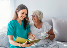 caretaker holding book beside old  woman