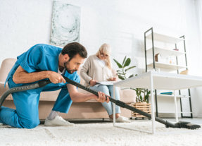 caretaker vacuuming carpet